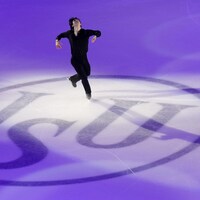 Un patineur effectue une figure sur le logo de l'ISU.