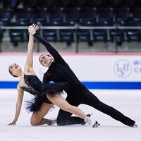 Un genou sur la glace, deux patineurs concluent leur programme.