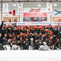 L'équipe des Patriotes de l'UQTR est regroupée autour d'un trophée après la conquête du titre canadien.
