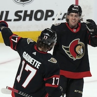 Deux joueurs se félicitent sur la glace après un but. 