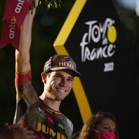 Un coureur soulève un bouquet de fleur après son arrivée aux Champs-Élysées lors de la conclusion du Tour de France. 