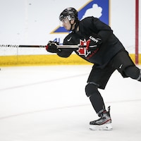 Xavier Bourgault lance une rondelle lors d'un entraînement de l'équipe junior canadienne. 