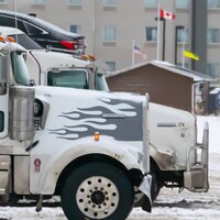 Des camions de livraison en hiver avec les drapeaux des États-Unis, du Canada et de la Saskatchewan.