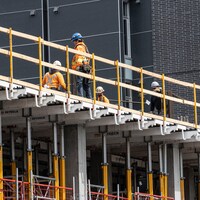 Des travailleurs sur le dessus d'une structure en construction.
