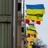 Les drapeaux de l'Ukraine, de la Saskatchewan et du Canada sont levés en alternance sur le pont de la rue Albert à Regina, en Saskatchewan, en mars 2022.