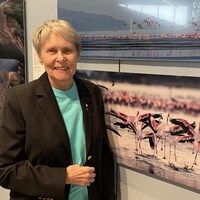 Roberta Bondar pose à côté d'une de ses photographie.
