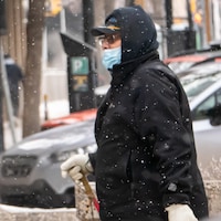 Des passants dans la rue avec un masque pour se protéger de la COVID-19 en Saskatchewan.
