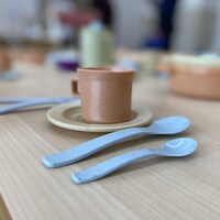 Des ustensiles et une tasse sur une table en bois.