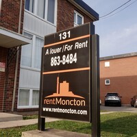 Affiche de logement à louer devant un immeuble d'habitation.