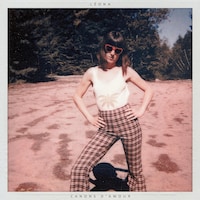 La pochette de l'album « Canons d'amour » de Léona; l'artiste est debout sur un terrain plein de sable et elle porte des lunettes de soleil en forme de coeur
