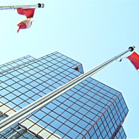Des drapeaux canadiens devant un édifice fédéral à Ottawa.
