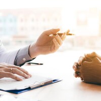 Un médecin tient un crayon en parlant à un patient.