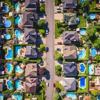 Vue aérienne de piscines et de maisons dans un quartier résidentiel typique de banlieue.