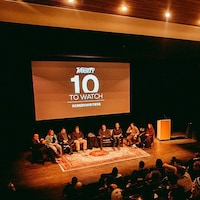 Huit personnes assises sur une scène devant un public au Festival du film de Whistler.