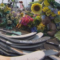 Des fleurs et des bâtons de hockey sont placés sur le lieu de l'accident d'autocar des Broncos de Humboldt en Saskatchewan.