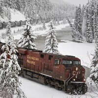Un train longeant une rivière, l'hiver.