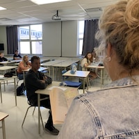 Une professeure lit un livre à des étudiants.