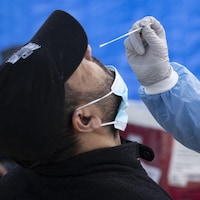 Une professionnelle de la santé effectue un test de dépistage du coronavirus dans une clinique mobile du quartier Saint-Michel.