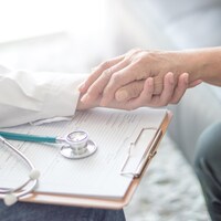 Un médecin tient la main d'une femme souffrant de la maladie de Parkinson.
