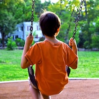 Un enfant se balance sur une balançoire dans un parc.