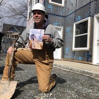 Ernie Steeves sur un genou, habillé en travailleur de la construction.