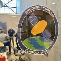 Un logo représentant une pomme de terre dans l'espace, sur la vitre d'un laboratoire.