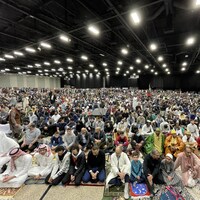 Plusieurs personnes musulmanes assises par terre sur les tapis pour la prière dans une grande salle du Centre des congrès RBC à Winnipeg, le 2 mai 2022.