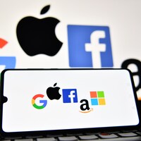 Les logos de Google, Apple, Facebook, Amazon et Windows affichés sur un téléphone intelligent et sur un écran d'ordinateur portable. 
