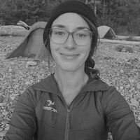 Geneviève Lauzon en camping sourit devant sa tente.