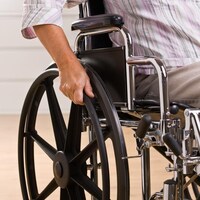 Une personne assise dans un fauteuil roulant.