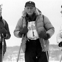 Le  skieur Herman « Jackrabbit » Smith-Johannsen est entouré de deux skieuses.