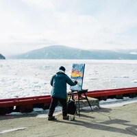 L'artiste Samuel Gagnon en train de peindre à l'Isle-aux-Coudres.