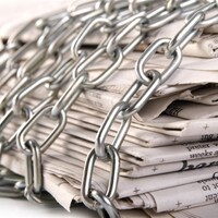 Une pile de journaux avec une chaîne en fer enroulée autour.
