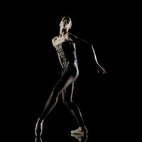 Une danseuse tient une pose de danse contemporaine. 