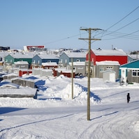 Vue d'un village enneigé, composé de dizaines de maisons colorées.