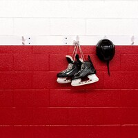 Des patins et un casque sont suspendus au mur d'un aréna.