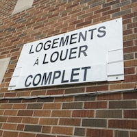 Une pancarte qui indique « Logements à louer. Complet » sur un immeuble.