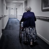 Une dame âgée dans un couloir.