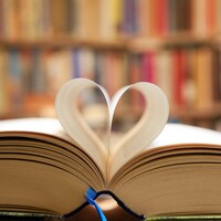 Un livre ouvert dont les pages pliées forment un coeur. 
