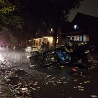 Une voiture renversée entourée de débris.