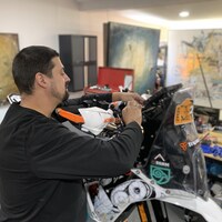 Étienne Gélinas en train de travailler sur une motocyclette.