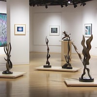 Des sculptures et des tableaux dans une galerie.