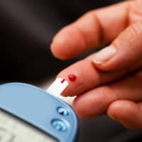 Une personne mesure son taux de glucose dans le sang.