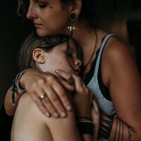 Une mère réconforte son enfant dans ses bras. 