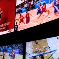 Des écrans diffusent des matchs de basketball et une publicité de la compagnie BetMGM.