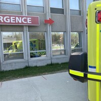 Une ambulance devant l'enseigne d'une urgence.