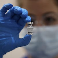 Une infirmière tient une capsule contenant le vaccin Pfizer/BioNTech dans sa main.
