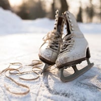 Des patins se trouvent sur une surface glacée à l'extérieur.