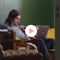 Le comédien Sam-Éloi est assis dans un salon. Il regarde un ordinateur, placé sur ses jambes. 
