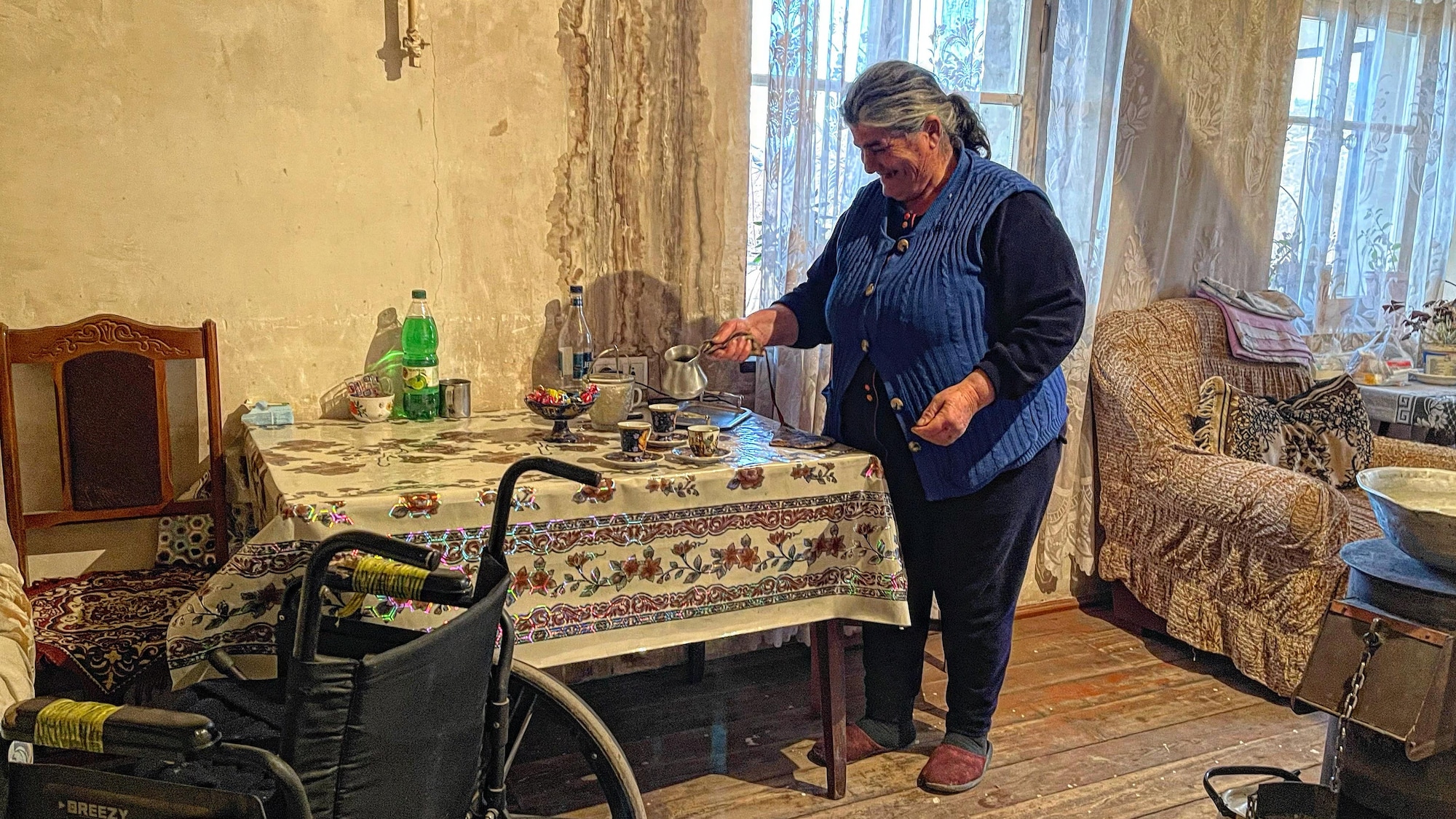 Une femme sert le café dans des tasses sur une table.